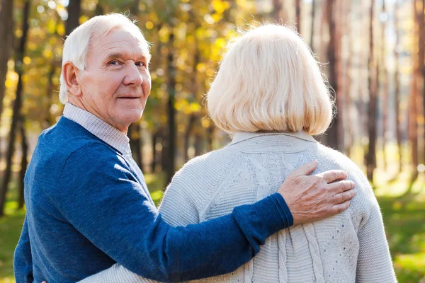 Happy senior man walking by park with wife — Stock Photo, Image