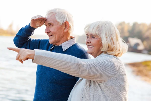 Lyckliga äldre par pekar bort — Stockfoto