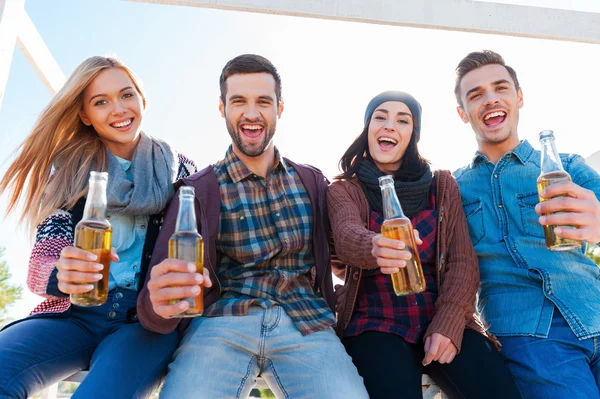 Junge fröhliche Menschen jubeln mit Bier — Stockfoto