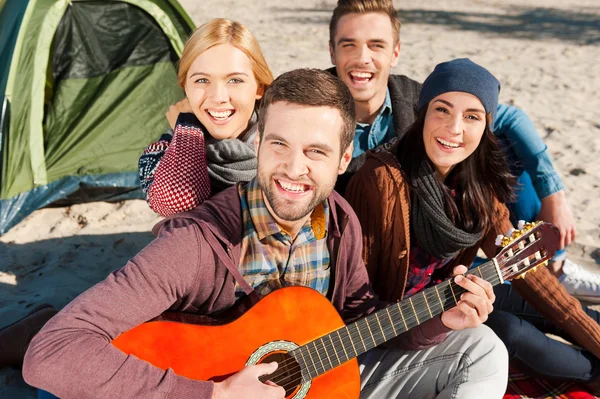 Giovani felici seduti vicino alla tenda — Foto Stock