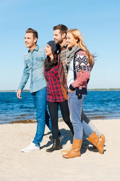 Gente feliz caminando por la playa — Foto de Stock