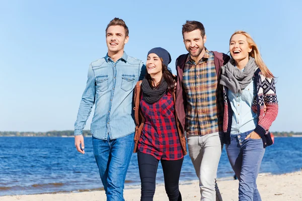 Gente feliz caminando por la playa juntos — Foto de Stock