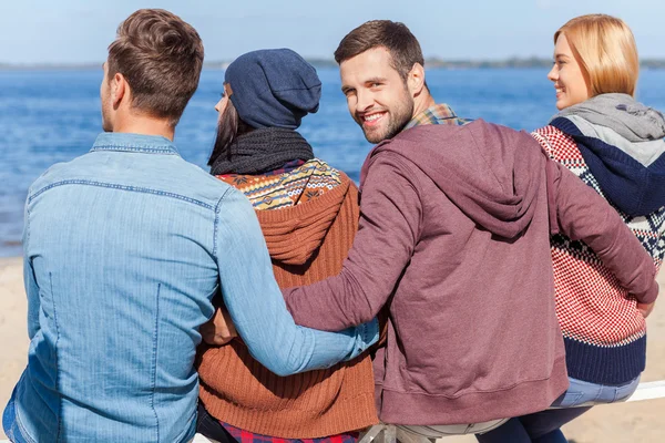 Quatre jeunes gens heureux profitant du temps à la plage — Photo