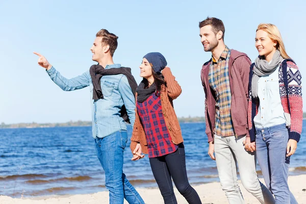 Yngre par promenader på stranden — Stockfoto