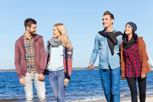 Beaux jeunes couples marchant sur la plage — Photo