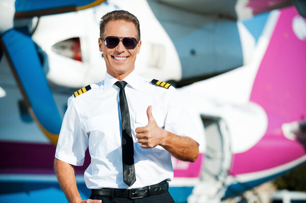 Pilot in uniform showing his thumb up