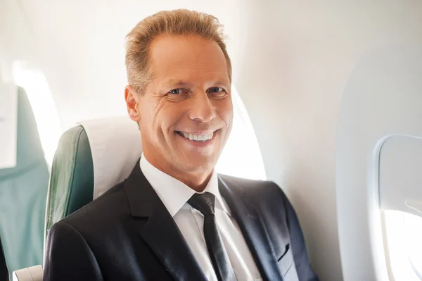 Uomo d'affari seduto al suo posto in aereo — Foto Stock