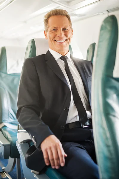 Liikemies istuu istuimellaan lentokoneessa — kuvapankkivalokuva