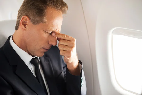 Frustrated mature businessman in airplane — Stock Photo, Image