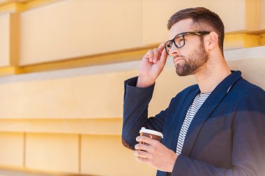 Kahve fincanı tutarak akıllı ceketli adamı