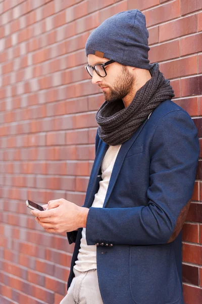 Homem em desgaste casual inteligente segurando telefone celular — Fotografia de Stock