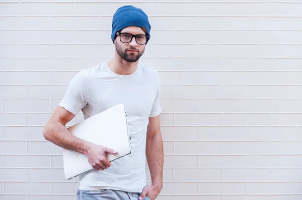Человек в очках держит ноутбук — стоковое фото