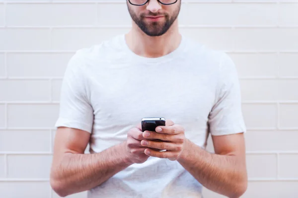 Homem de óculos digitando no celular — Fotografia de Stock