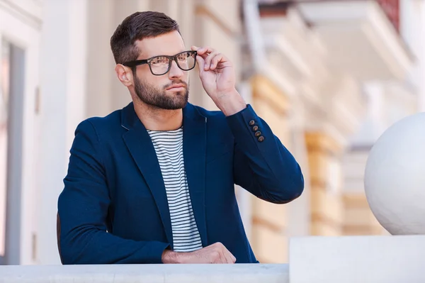 Uomo in abbigliamento casual intelligente che regola i suoi occhiali — Foto Stock