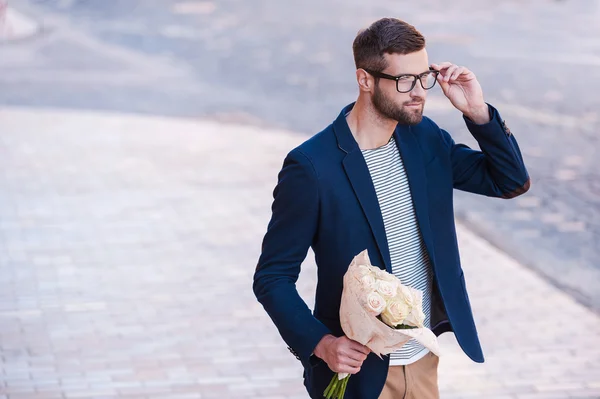 Man in casual wear holding bouquet of flowers — Stock Photo, Image