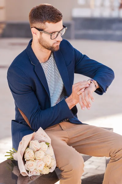 Чоловік в розумній куртці дивиться на свій годинник — стокове фото