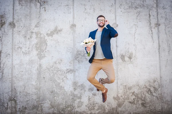 Man holding bouquet of flowers and jumping — Stock Photo, Image