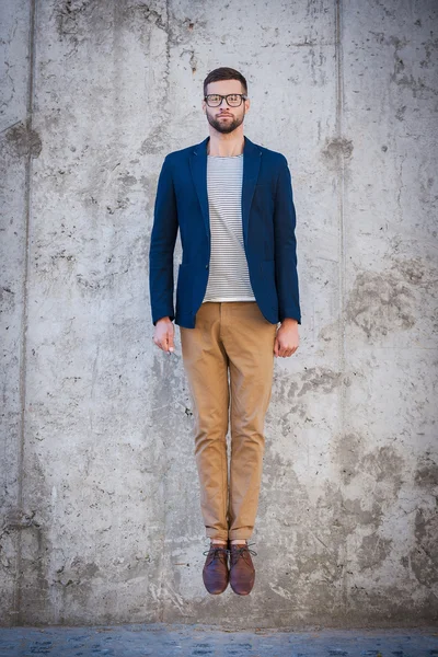 Young man in smart jacket jumping — Stock Photo, Image