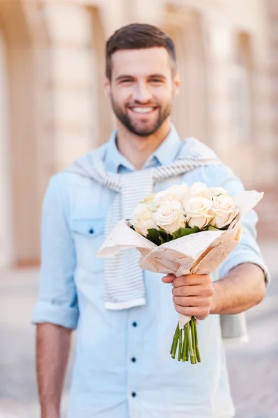 Jeune homme tenant bouquet de fleurs — Photo