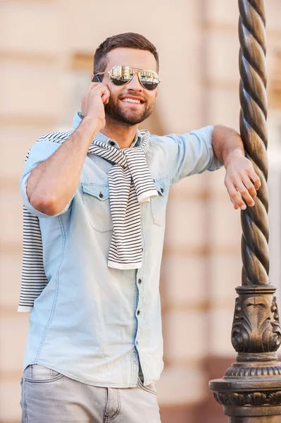 Jeune homme en lunettes de soleil parlant sur le téléphone mobile — Photo