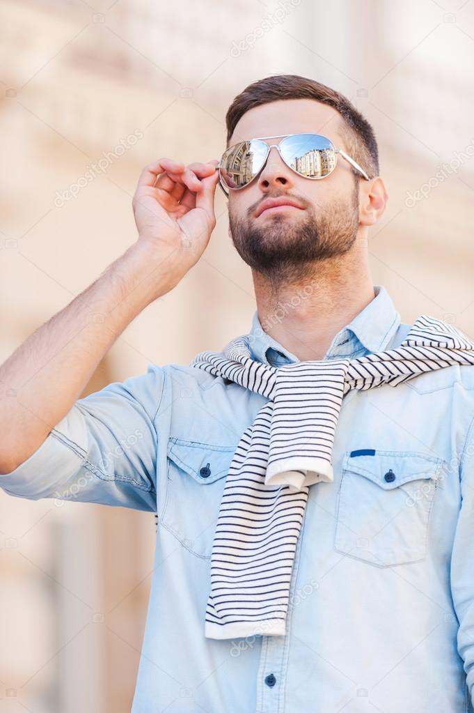 Young man adjusting his sunglasses