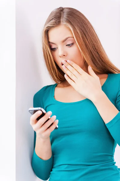 Mujer sorprendida sosteniendo el teléfono — Foto de Stock