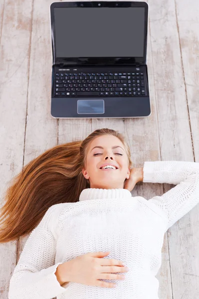 Mujer acostada en el suelo con portátil — Foto de Stock