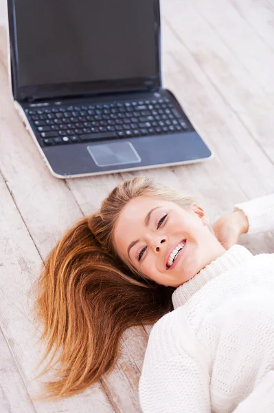 Vrouw met laptop op de vloer liggen — Stockfoto
