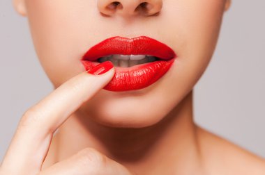 Beautiful woman holding finger on her red lips clipart