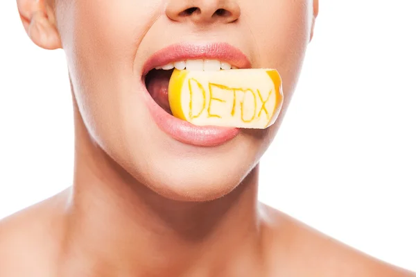 Shirtless woman holding piece of apple in mouth — Stock Photo, Image