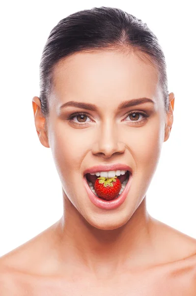 Frau ohne Hemd hält Erdbeere im Mund — Stockfoto