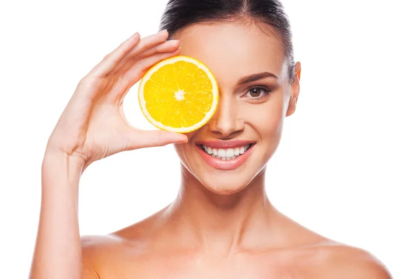 Shirtless woman holding piece of orange — Stock Photo, Image