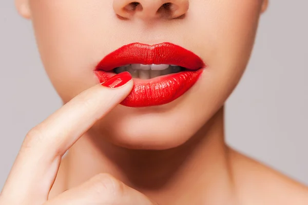 Beautiful woman holding finger on her red lips — Stock Photo, Image