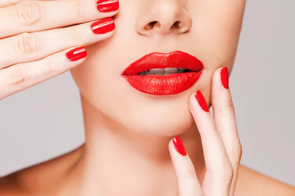 Mujer sosteniendo el dedo en sus labios rojos — Foto de Stock