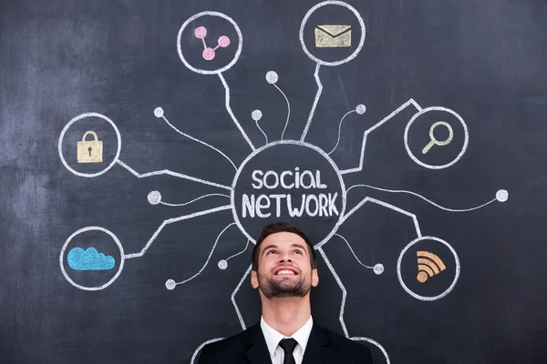 Man standing under social network chalk drawing — Stock Photo, Image