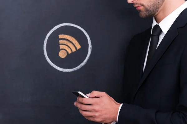 Man met telefoon terwijl staande tegen delen symbool — Stockfoto