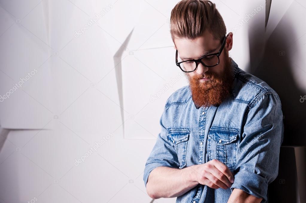 Bearded man rolling up sleeves