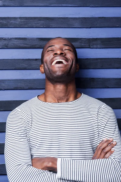 Afrykański mężczyzna utrzymanie ręce skrzyżowane i śmiejąc się — Zdjęcie stockowe