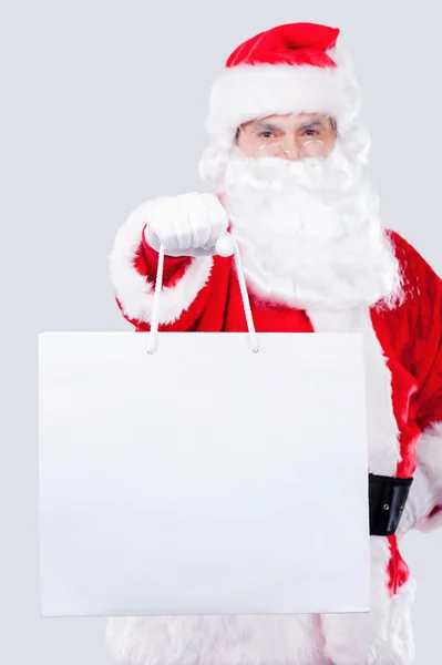 Санта Клаус протягивает руку с сумкой для покупок — стоковое фото