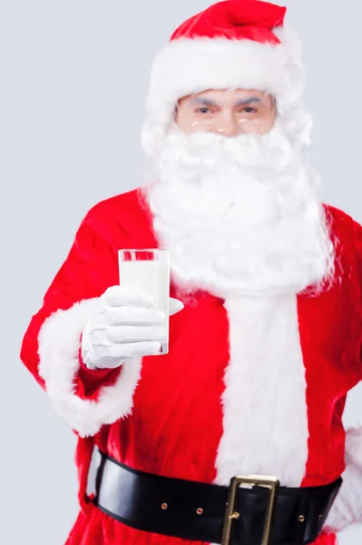 Santa Claus sträcker ut handen med glas mjölk — Stockfoto