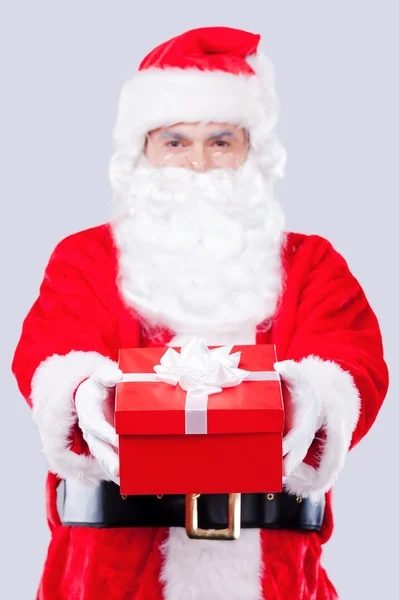 Santa Claus sträcker ut presentförpackning — Stockfoto