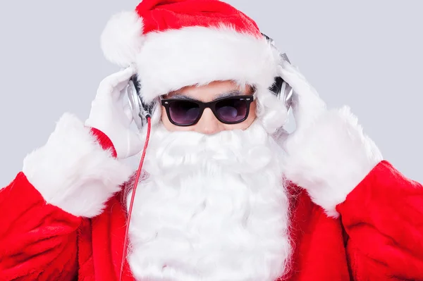 Papai Noel em óculos de sol ajustando seus fones de ouvido — Fotografia de Stock