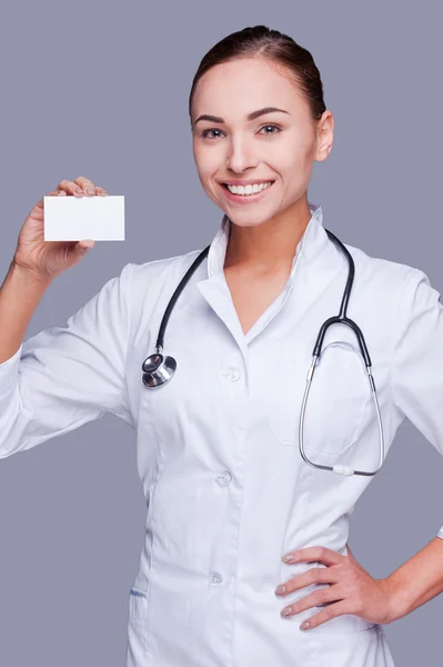 Médico feminino segurando cartão de visita — Fotografia de Stock