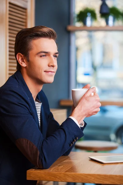 カフェでコーヒーを楽しんでいる若い男 — ストック写真