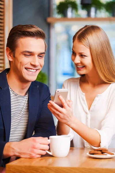 Žena ukazuje mobilní telefon na přítele — Stock fotografie