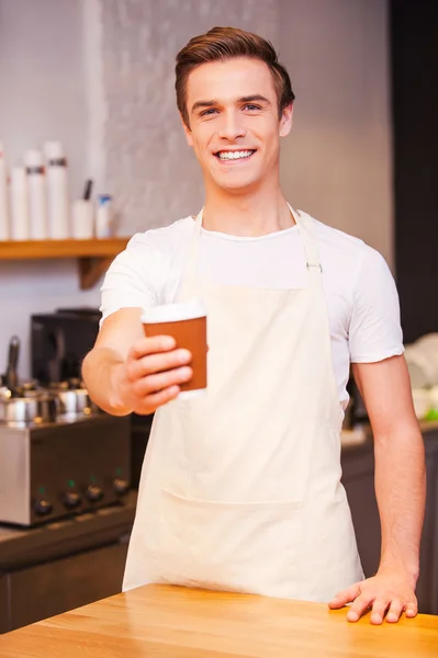 Male barista stretching out cup of coffee — Stock Photo, Image