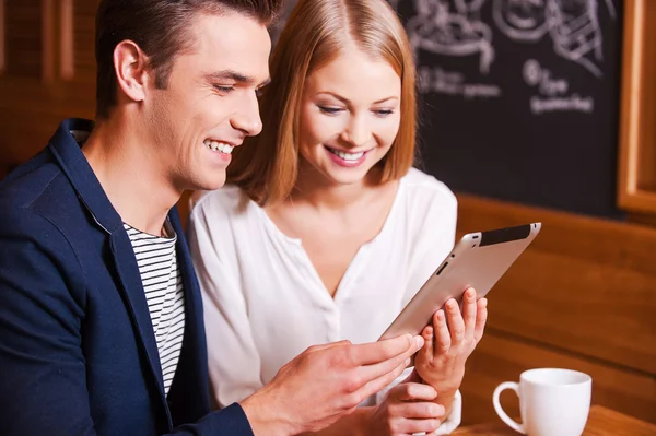 Paar kijken naar de digitale tablet in café Stockfoto