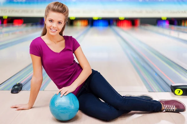 Vrouw zitten tegen bowlingbanen — Stockfoto