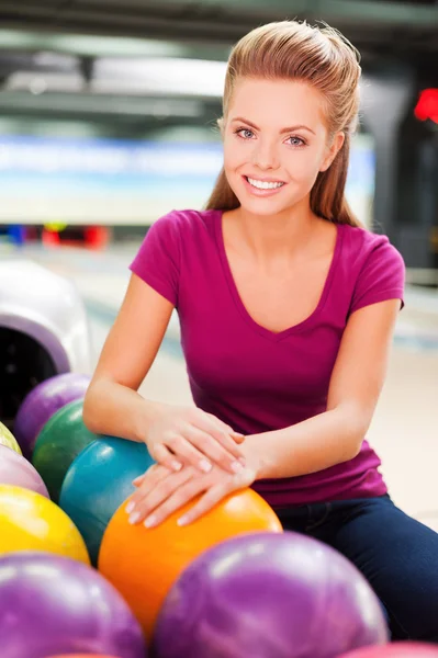 Woman holding hands on bowling ball — Stock Photo, Image