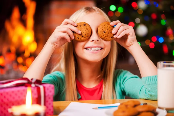 Kleines Mädchen bedeckt ihre Augen mit Keksen — Stockfoto